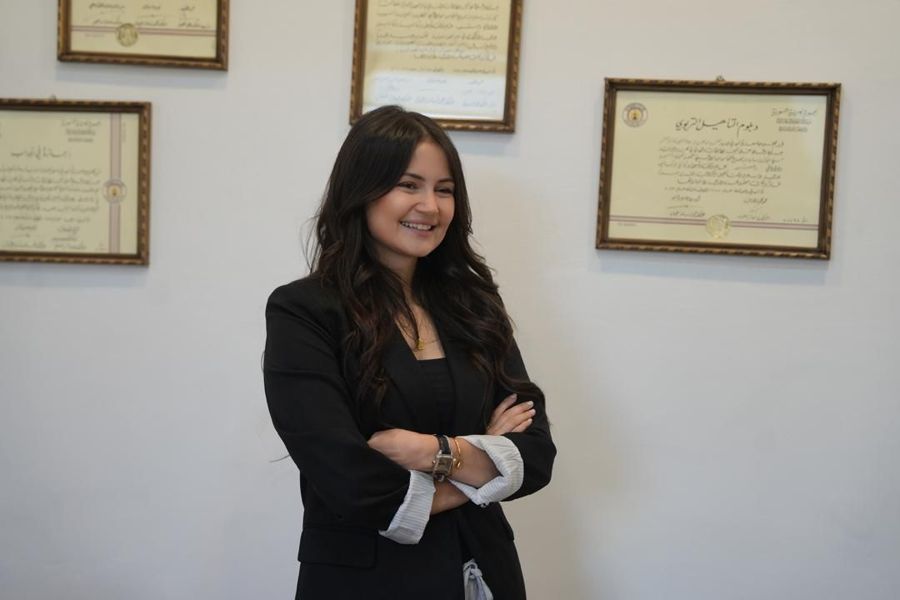 د. سارة في عيادتها أمام شهاداتها